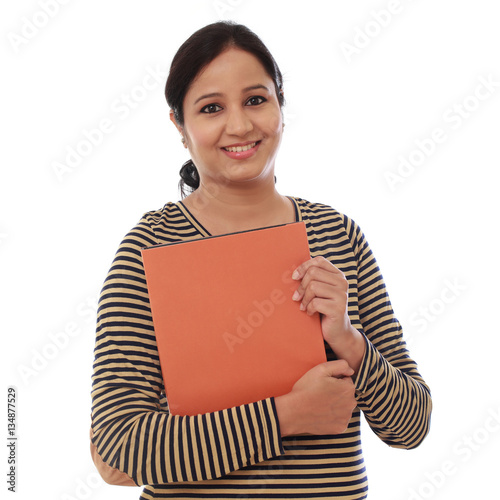 Happy female student holding text book