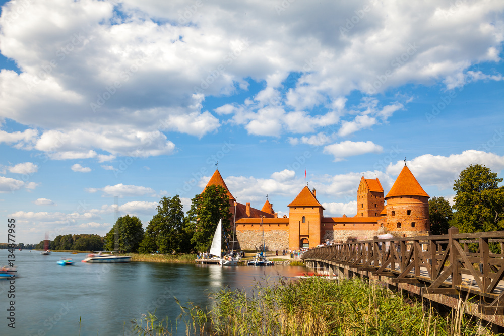 Tourists visit Trakai castle in sunny siummer day, nice time to have boat trip. Long exposure, motion blur