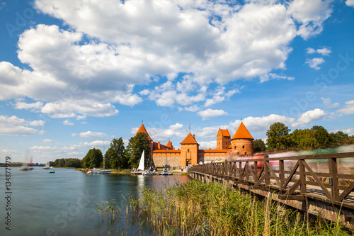 Tourists visit Trakai castle in sunny siummer day, nice time to have boat trip. Long exposure, motion blur