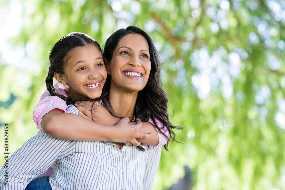 Happy mother giving piggyback ride to her daughter Happy mother giving piggyback ride to her daughter