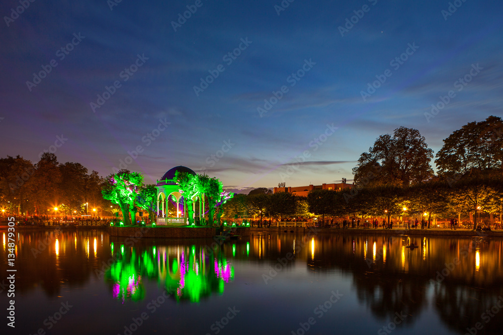 Festival of lights in city park, pond with illuminated rotunda. Tallinn, Estonia