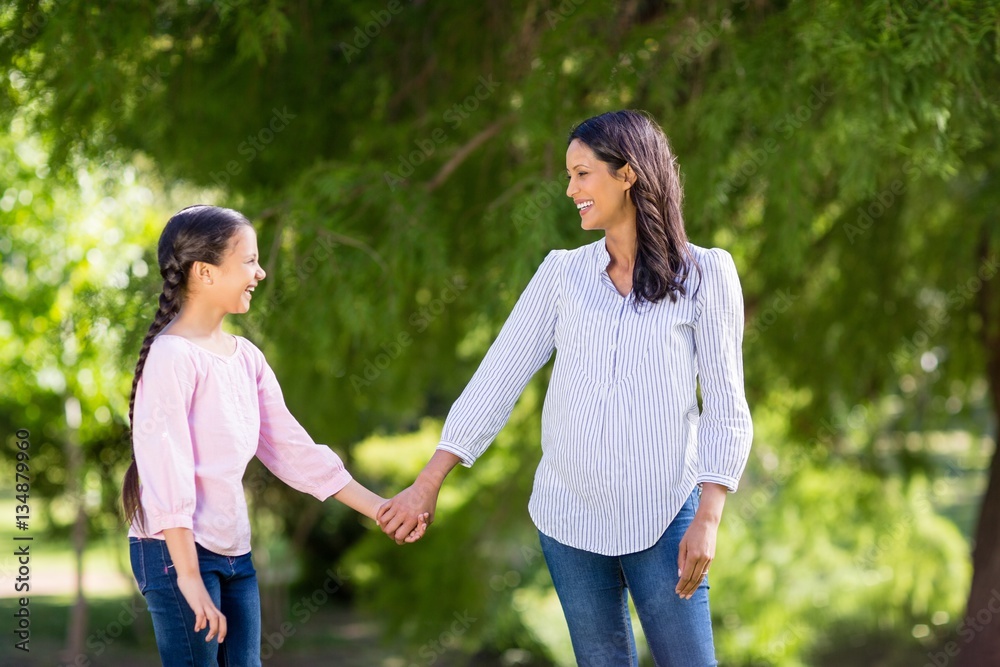 Mother holding hands of her daughter in park Mother holding hands of her daughter in park