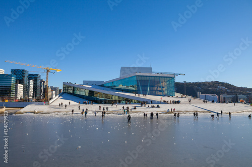 Oslo Opera house with walking and relaxing people at sunny winter day