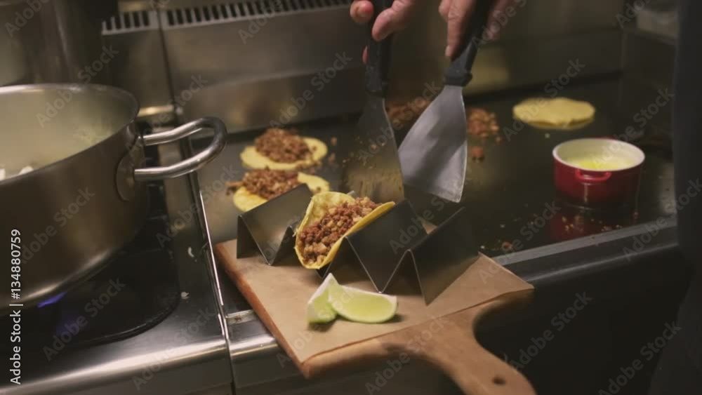 Chef cooking delicious mexican tacos in a restaurant.