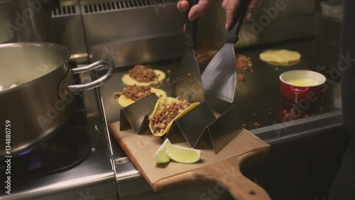 Chef cooking delicious mexican tacos in a restaurant.