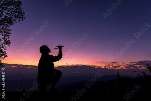 The silhouette of a woman Happy drinking water at sunset.