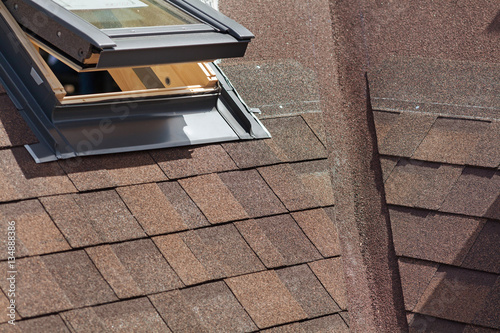 Foto Closeup of window skylight on a roof with Asphalt Shingles or Bitumen Tiles unde