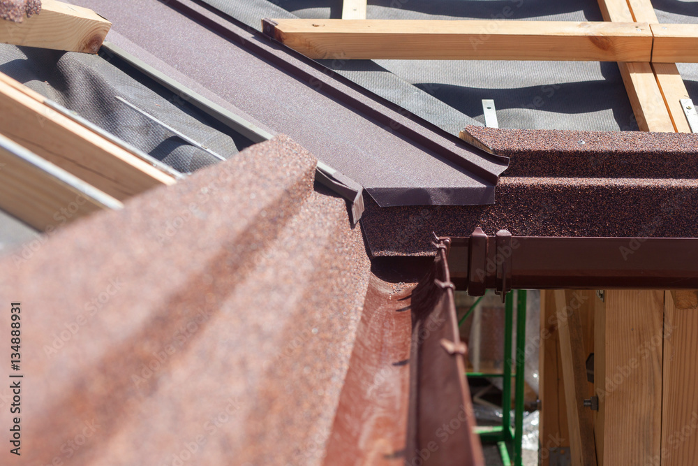 New asphalt shingle roof with brown rain gutter, wooden beams and vapour control layer New asphalt shingle roof with brown rain gutter, wooden beams and vapour control layer