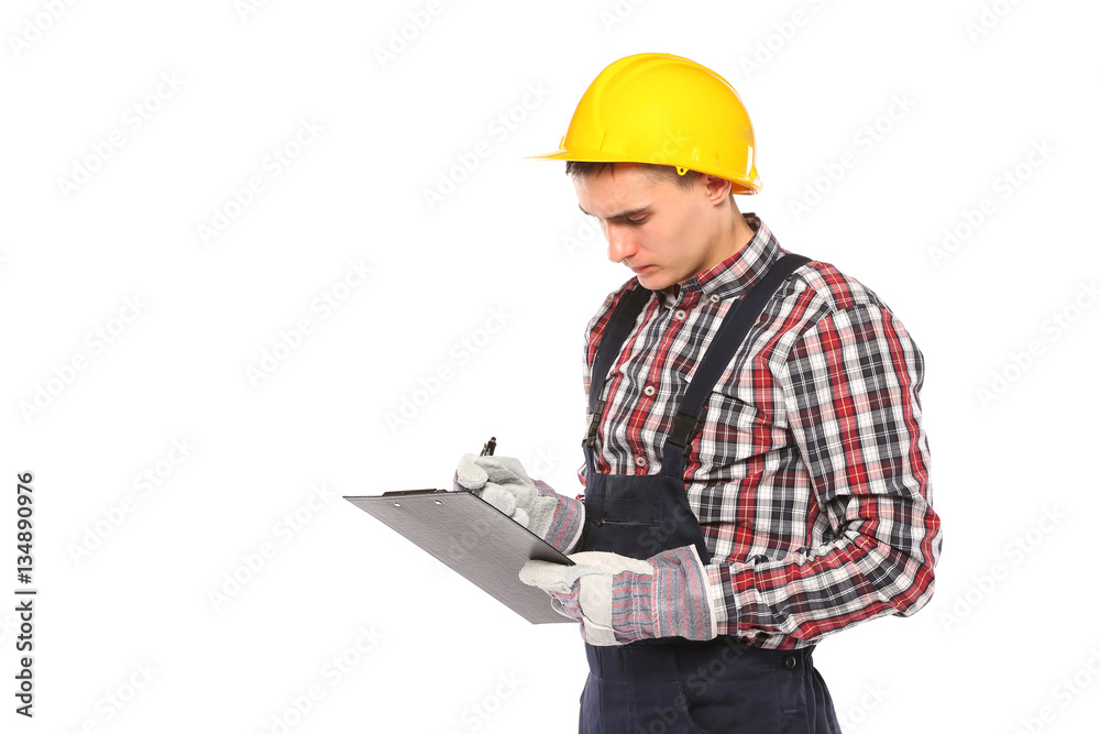 young worker with yellow helmet and gloves, writes in the book young worker with yellow helmet and gloves, writes in the book