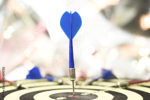 marketing or target arrow concept on light bokeh abstract background, Target hit in the center by blue arrows. ( soft focus )