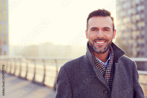 Portrait of handsome man wearing coat during cold winter evening