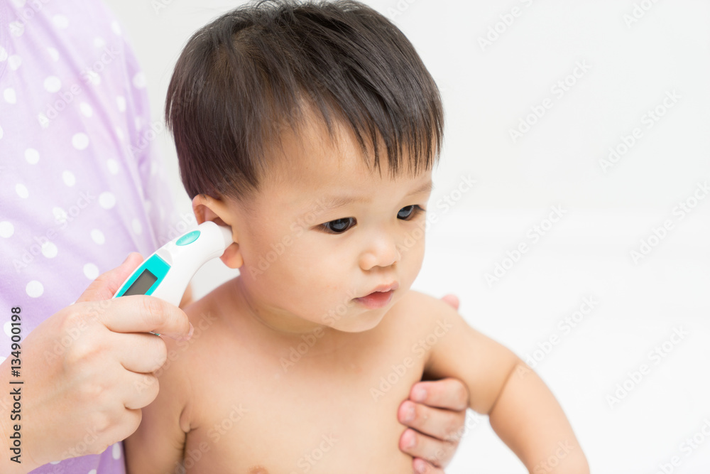 Mother uses the thermometer for Asian baby Mother uses the thermometer for Asian baby
