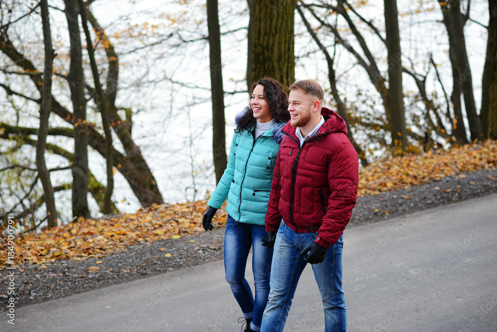 Lovers walking hand in hand in autumn park Lovers walking hand in hand in autumn park