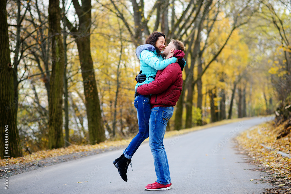 Portrait of young loving couple kissing in autumn park Portrait of young loving couple kissing in autumn park