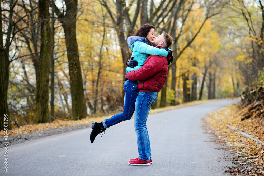 Portrait of young loving couple kissing in autumn park Portrait of young loving couple kissing in autumn park