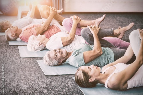 Fototapeta Naklejka Na Ścianę i Meble -  Instructor performing yoga with seniors