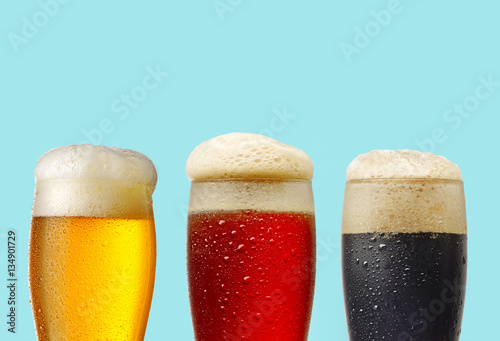 various beer glasses on blue background