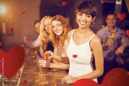 Composite image of portrait of friends having tequila in bar