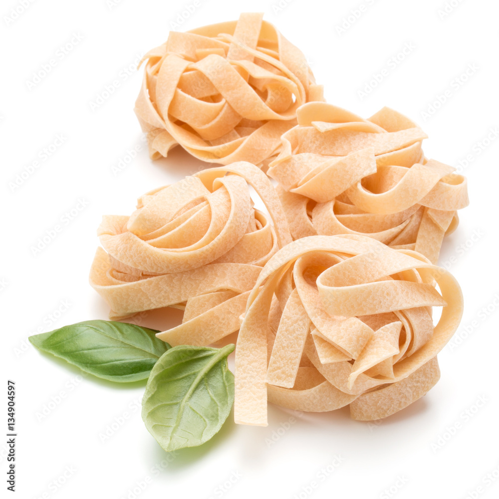 Italian pasta fettuccine nest and basil leaves  isolated on whit