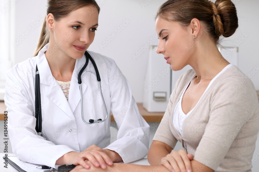 Doctor reassuring her female patient while bad news listening. Medicine, help and health care concept Doctor reassuring her female patient while bad news listening. Medicine, help and health care concept