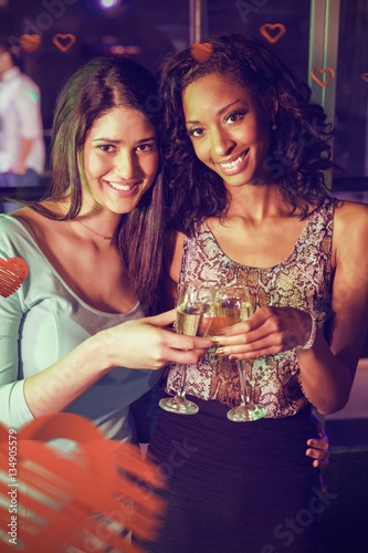 Composite image of portrait of women toasting champagne glasses