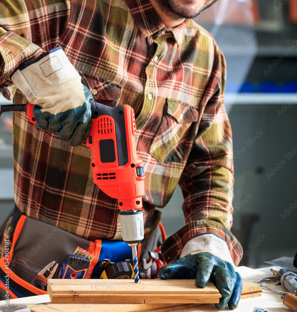 Worker holding an electric drill Worker holding an electric drill