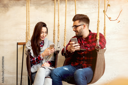 Couple enjoying talking and using their phones.