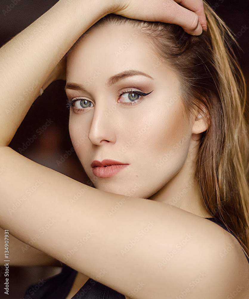 Naklejka premium Portrait of young pretty woman with perfect trendy nude makeup, gray eyes and long hair.