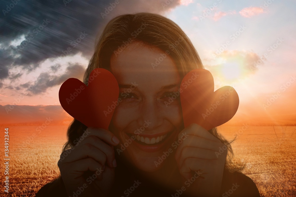 Composite image of woman holding heart cards 