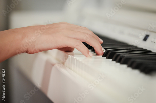 Hand playing on digital piano. Close-up. Small depth of field.