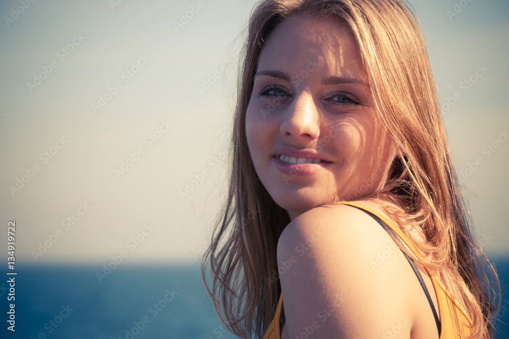Lovely blonde girl relaxing outdoor by seaside Lovely blonde girl relaxing outdoor by seaside