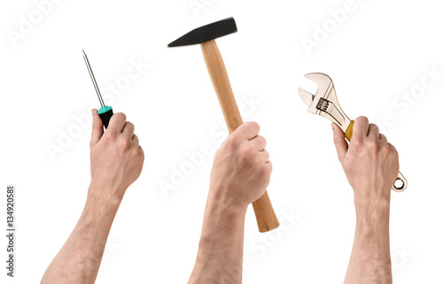 Three hands with screwdriver, hammer, and wrench on white background
