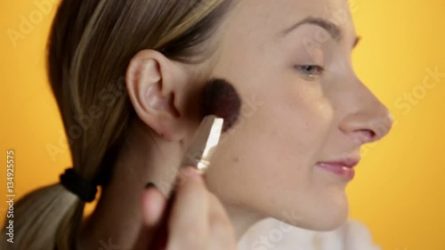 Female beauty, beautiful mid adult woman putting on fard and make-up