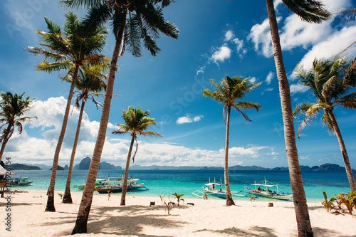 Tropical beach with palm trees  pilippine boats. Paradise. Philippines.