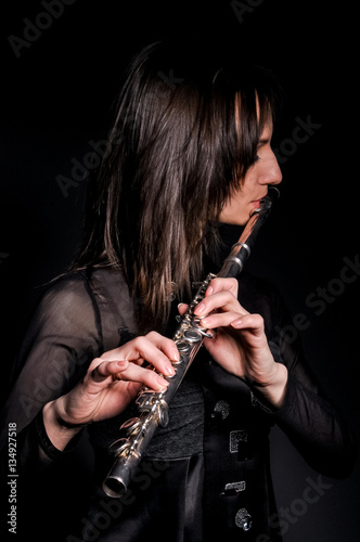 a young girl playing the flute