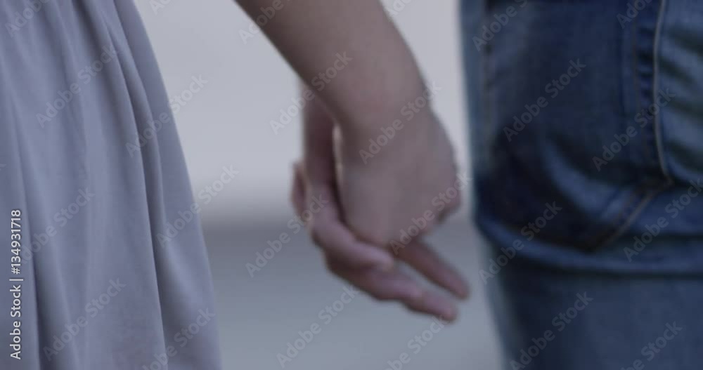 A couple is holding hands and lets go