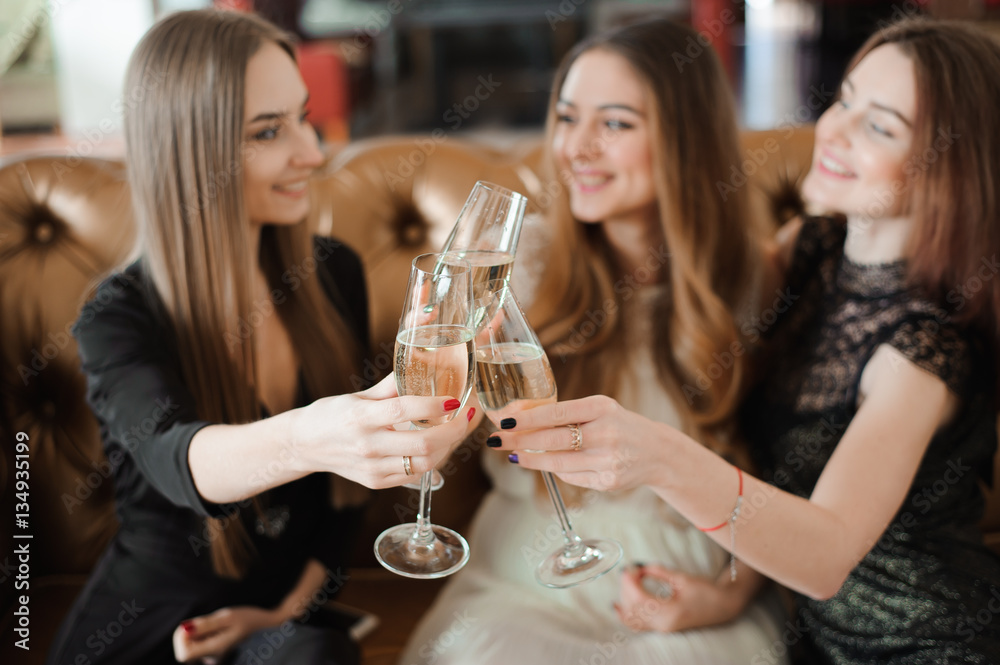 Cheerful girls clinking glasses of champagne at the party