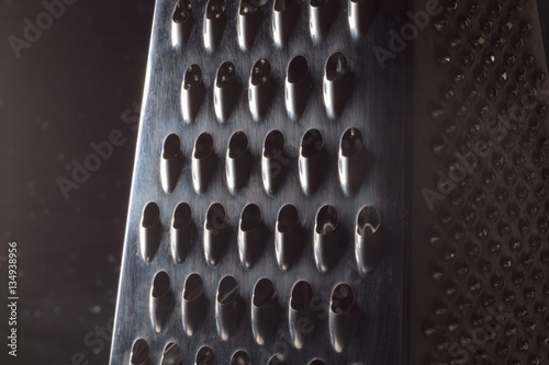 Close-up photo of a metal grater in a black background 