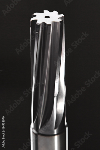 Metal reamer on black background. Professional cutting tools used for metalwork. Multiflute drill, broach bit, metal reamer, milling cutter