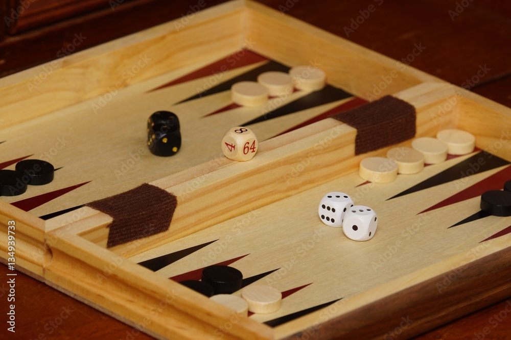 Naklejka premium Cubes and game pieces on a backgammon board