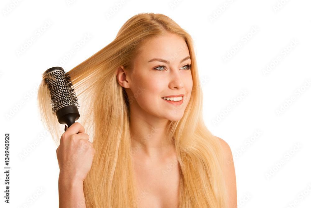 Beautiful blonde woman brushing her hair as a sign og hair care Beautiful blonde woman brushing her hair as a sign og hair care