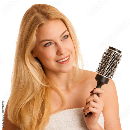 Beautiful blonde woman brushing her hair as a sign og hair care