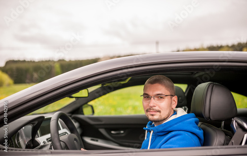 Man in luxury coupe car