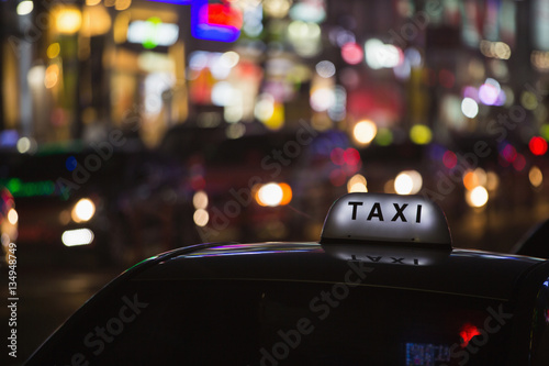 Taxi roof on a background of neon signs night city © scharfsinn86