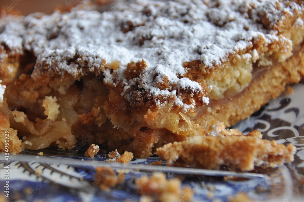 Apple pie dusted with icing sugar on the kitchen table. Apple pie dusted with icing sugar on the kitchen table.
