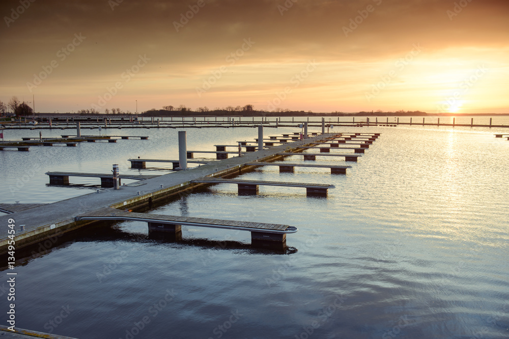 Obraz premium Yacht port over orange sunset
