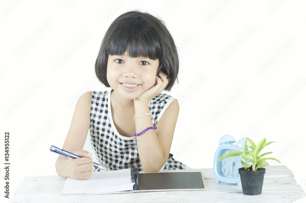 Young Asian girl writing on table isolated on white background Young Asian girl writing on table isolated on white background