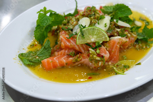 Salmon spicy salad in the white plate, Thailand