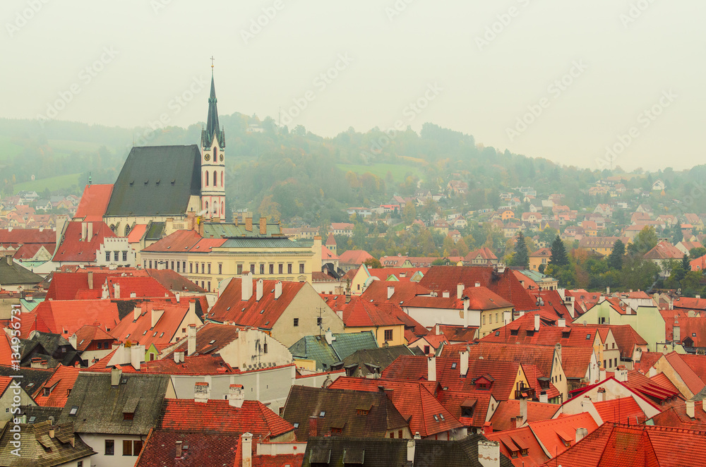 Cesky Krumlov - a famous czech historical beautiful town frome above, travel background with red roofs and chapel