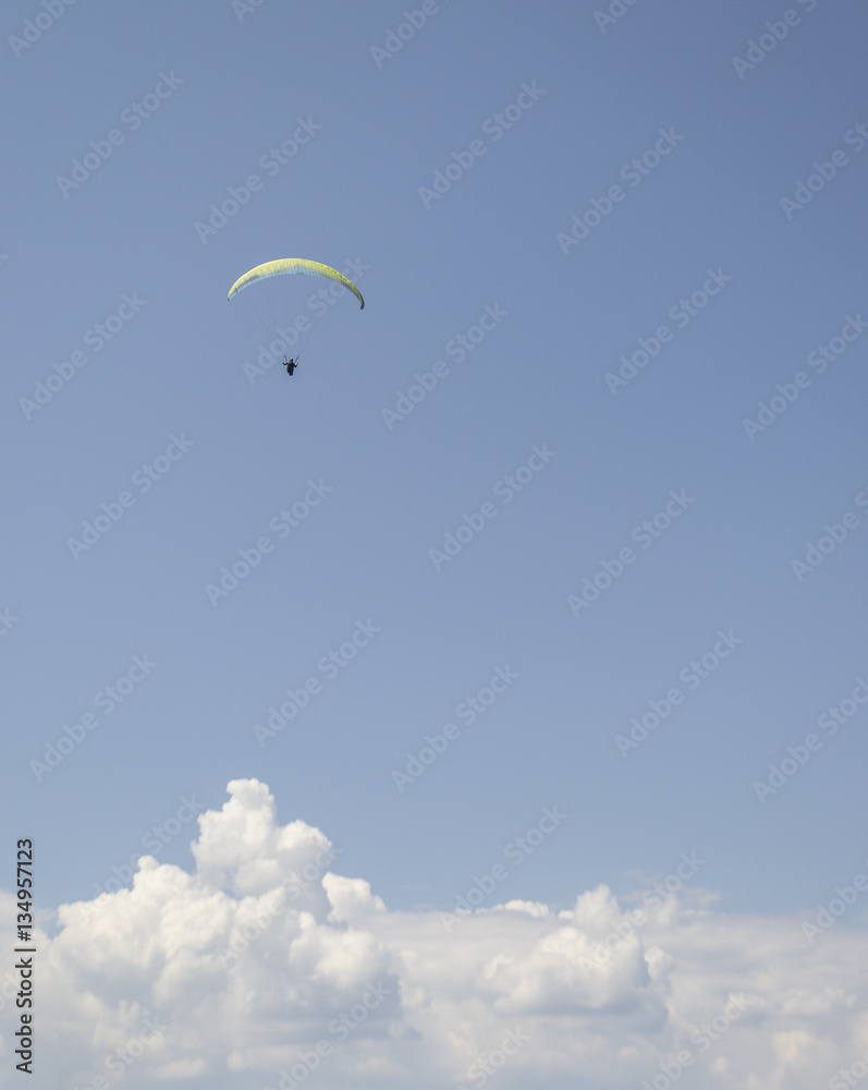 Flying parachute, high in the clouds on blue sky Flying parachute, high in the clouds on blue sky